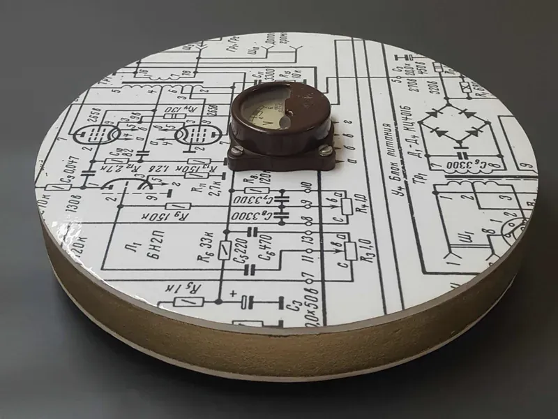 Analog voltmeter resting on an electrical circuit schematic