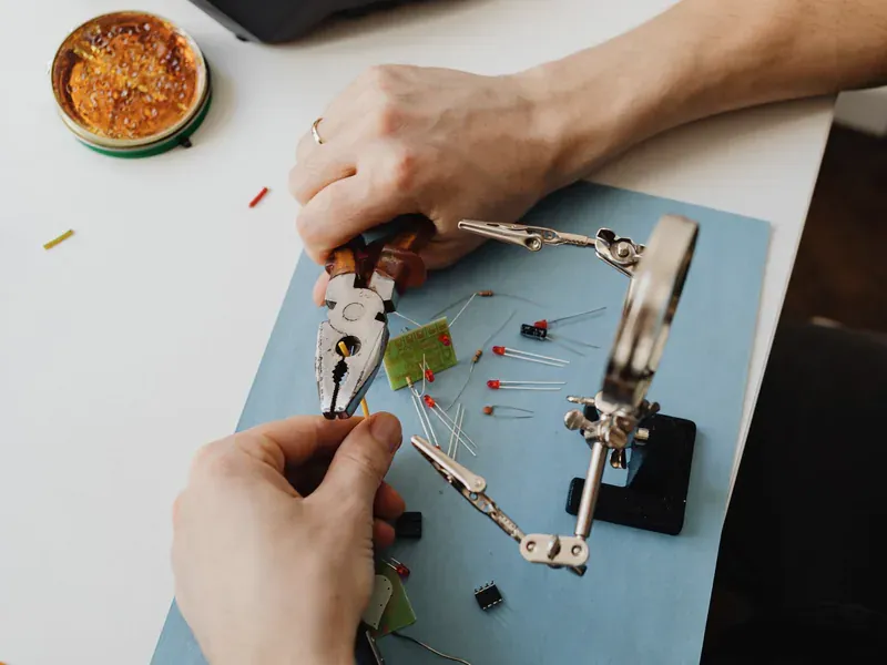 Hands assembling small electronic components on a workbench