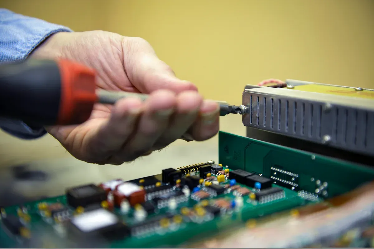 Aviation electronics technician testing a component in a precision laboratory