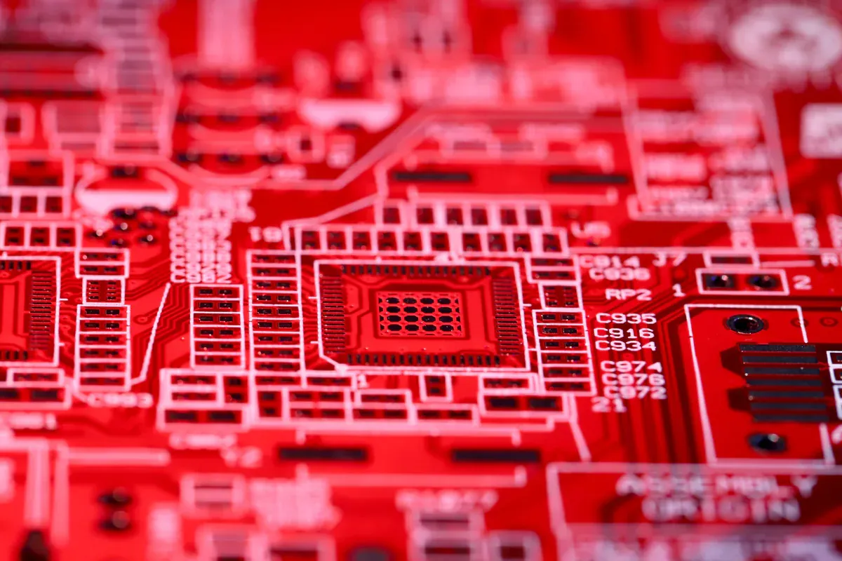Macro view of a surface-mount processor footprint on a red circuit board