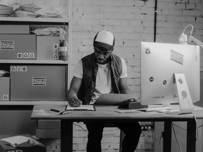 Worker checking labels on packaged goods in a warehouse