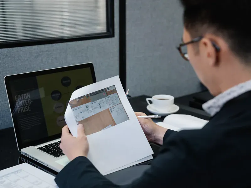 Engineer reviewing technical documents at a laptop