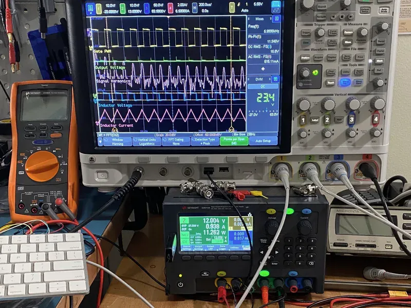Oscilloscope, digital multimeter, and power supply operating on a laboratory bench