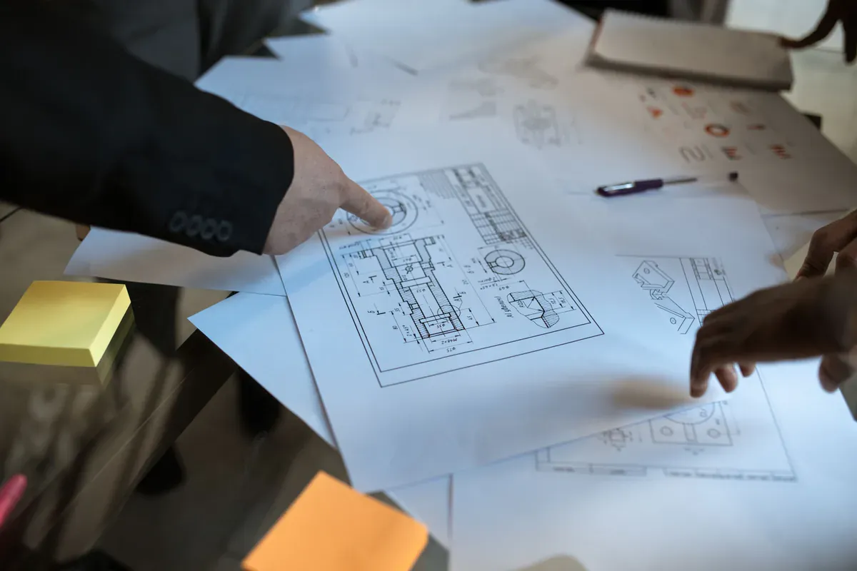 Engineers reviewing controlled technical drawings and procurement documents