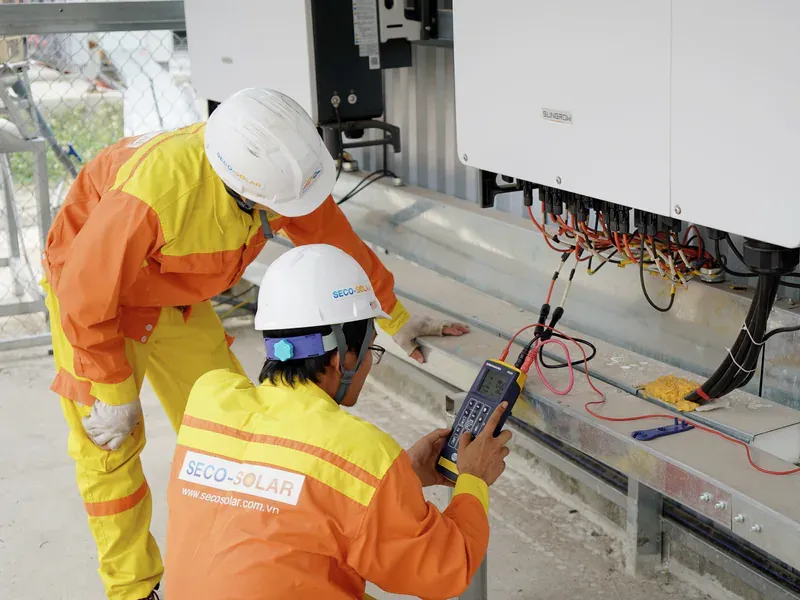 Electrical engineers testing solar power equipment at an installation