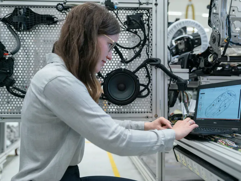 Engineer consulting a laptop while working with electronic equipment