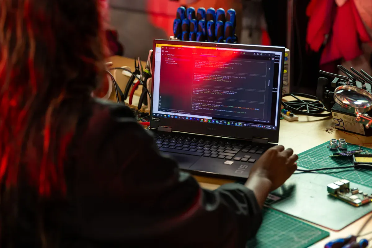 Engineer reviewing electronics hardware and software at a workbench