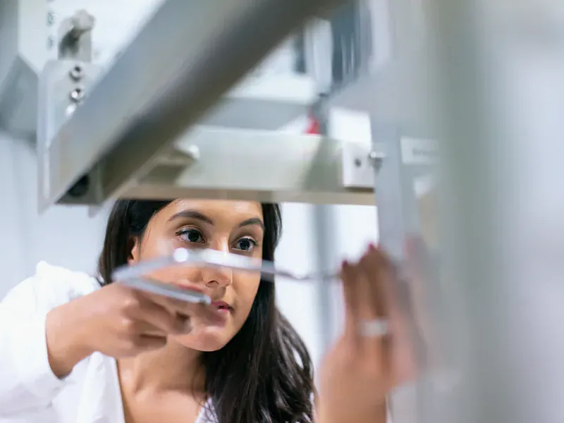 Engineer monitoring laboratory equipment during controlled electronics testing