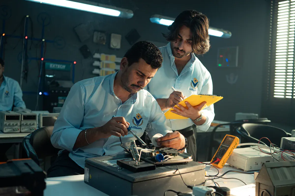 Electronics technicians reviewing a circuit board together