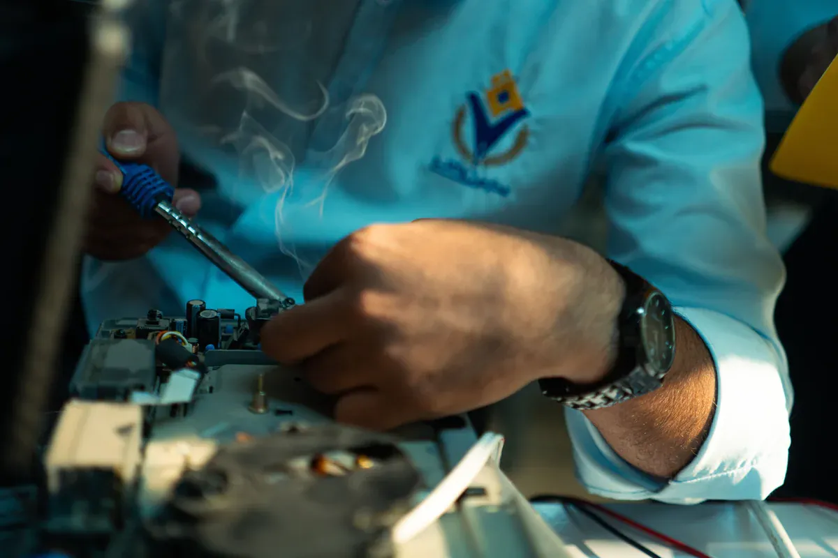 Electronics technician inspecting a circuit board after assembly