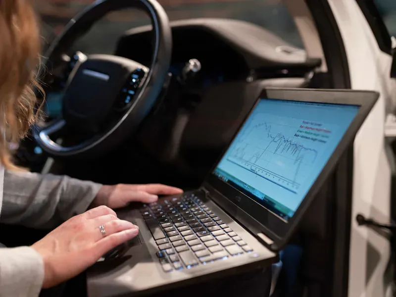 Engineer using a laptop to analyze vehicle diagnostic data