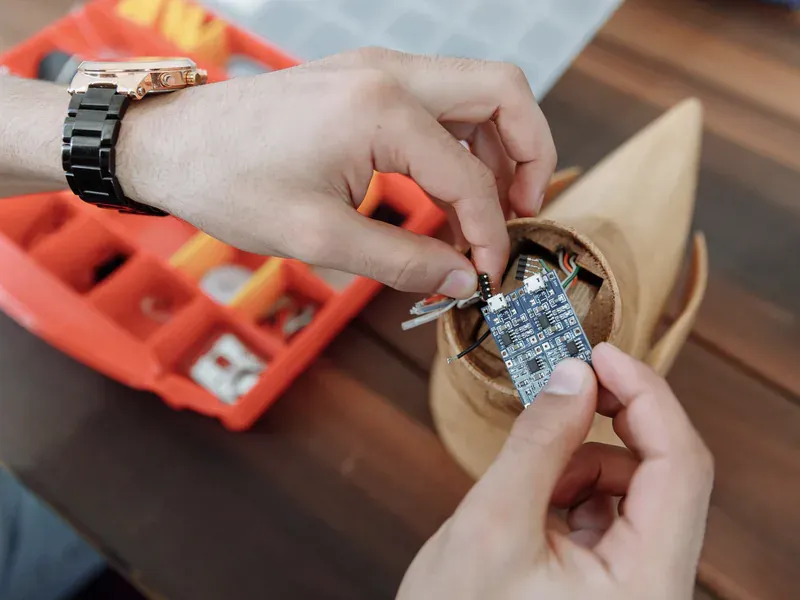 Hands adjusting a wired microcontroller prototype