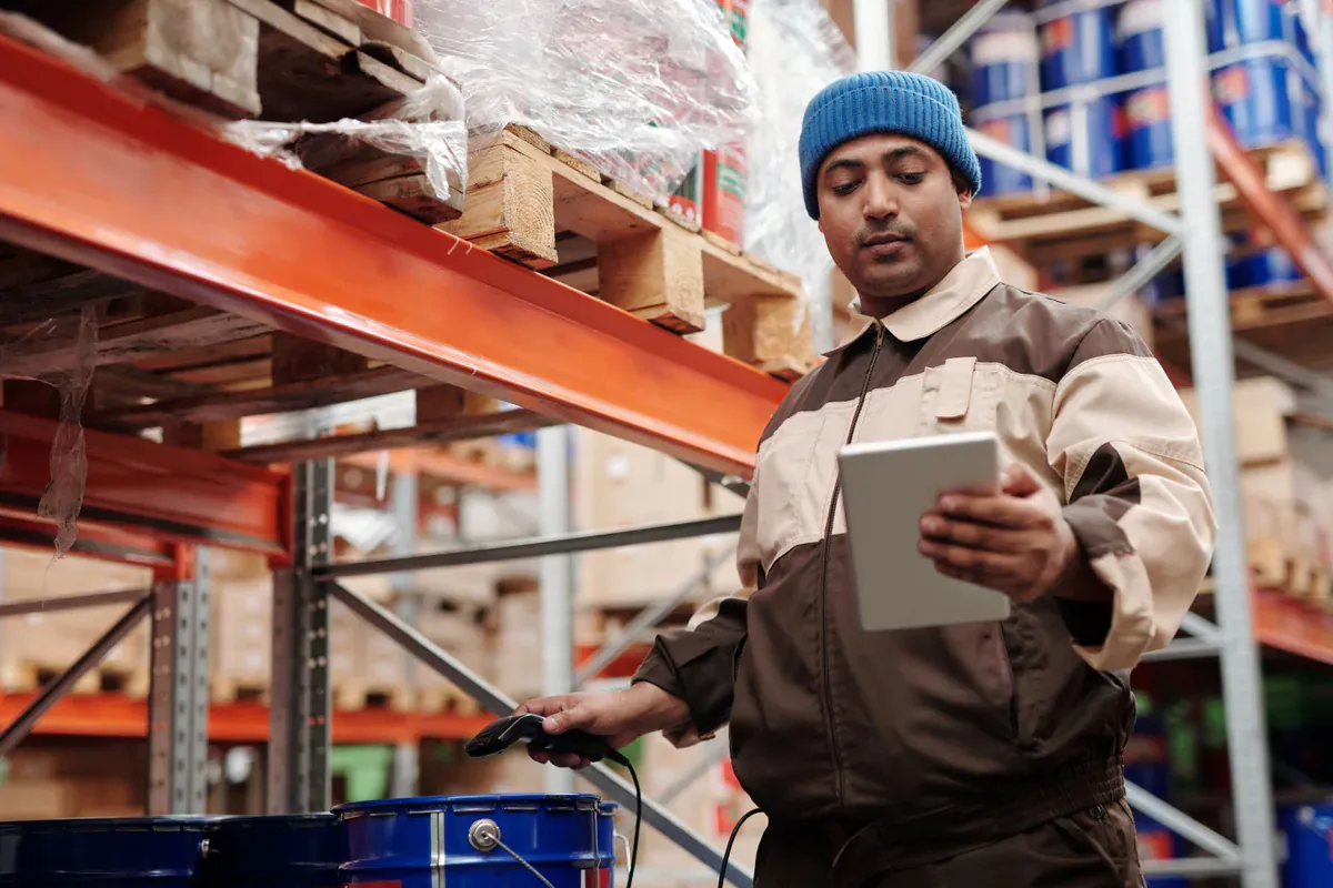 Warehouse inventory being checked with a handheld tablet scanner
