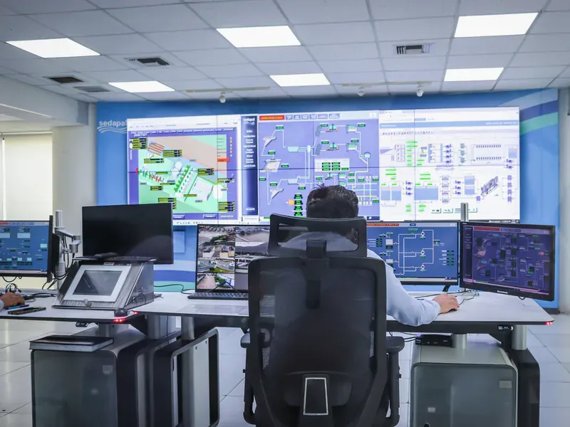 Operator monitoring industrial control and data systems from a control room
