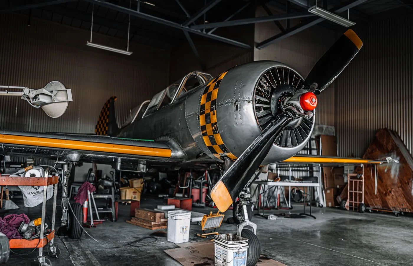 Aircraft undergoing maintenance inside an aviation hangar