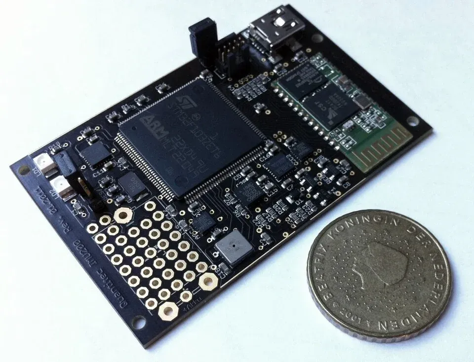 Inertial sensor circuit board beside a coin for scale