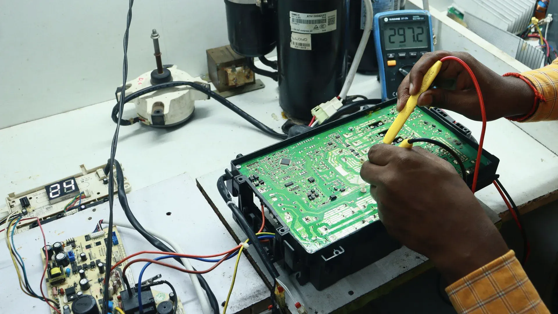 Technician testing a circuit board with probes and bench equipment during current-sensing validation