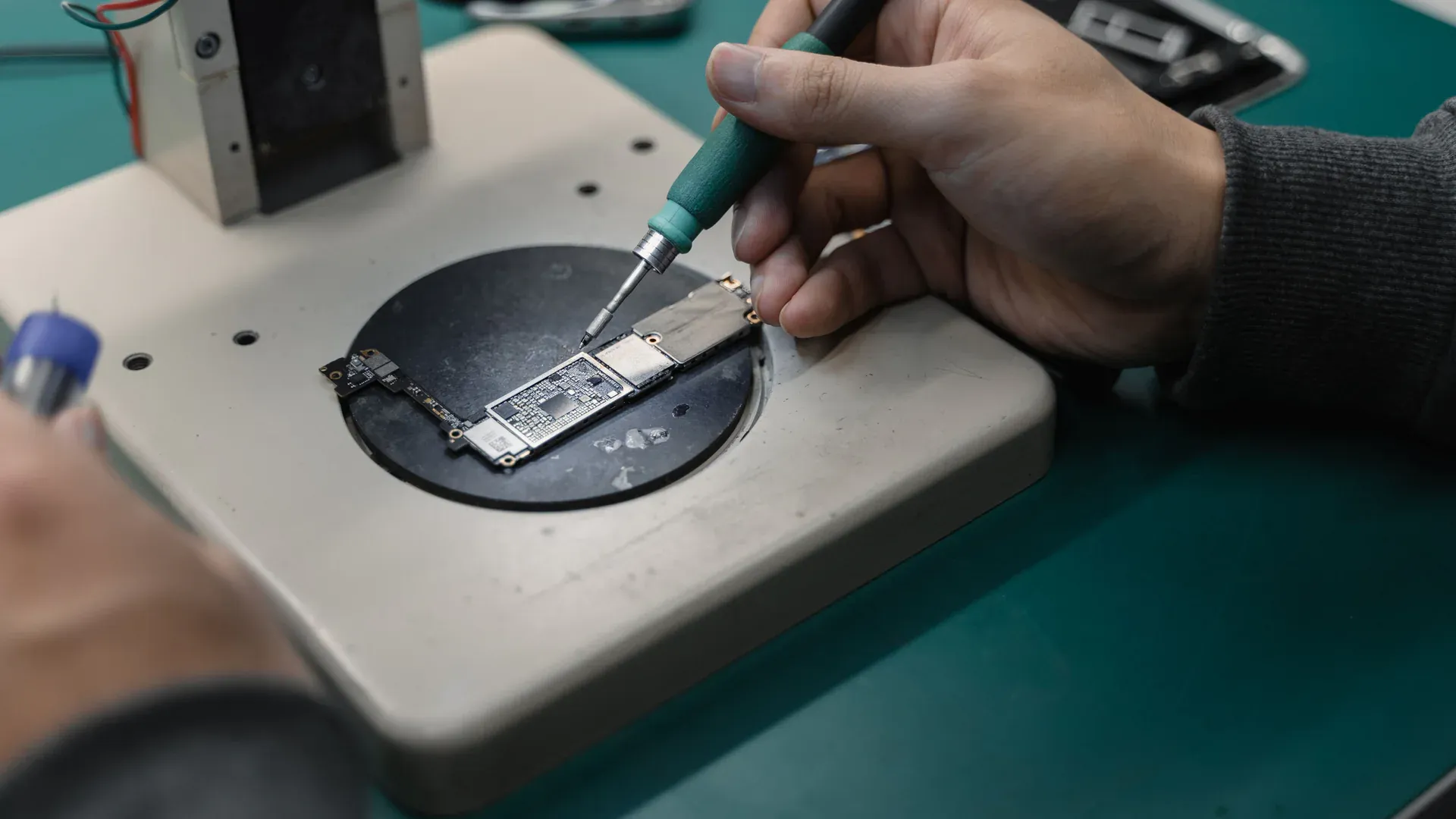 Technician working on a microelectronic assembly at a laboratory soldering station