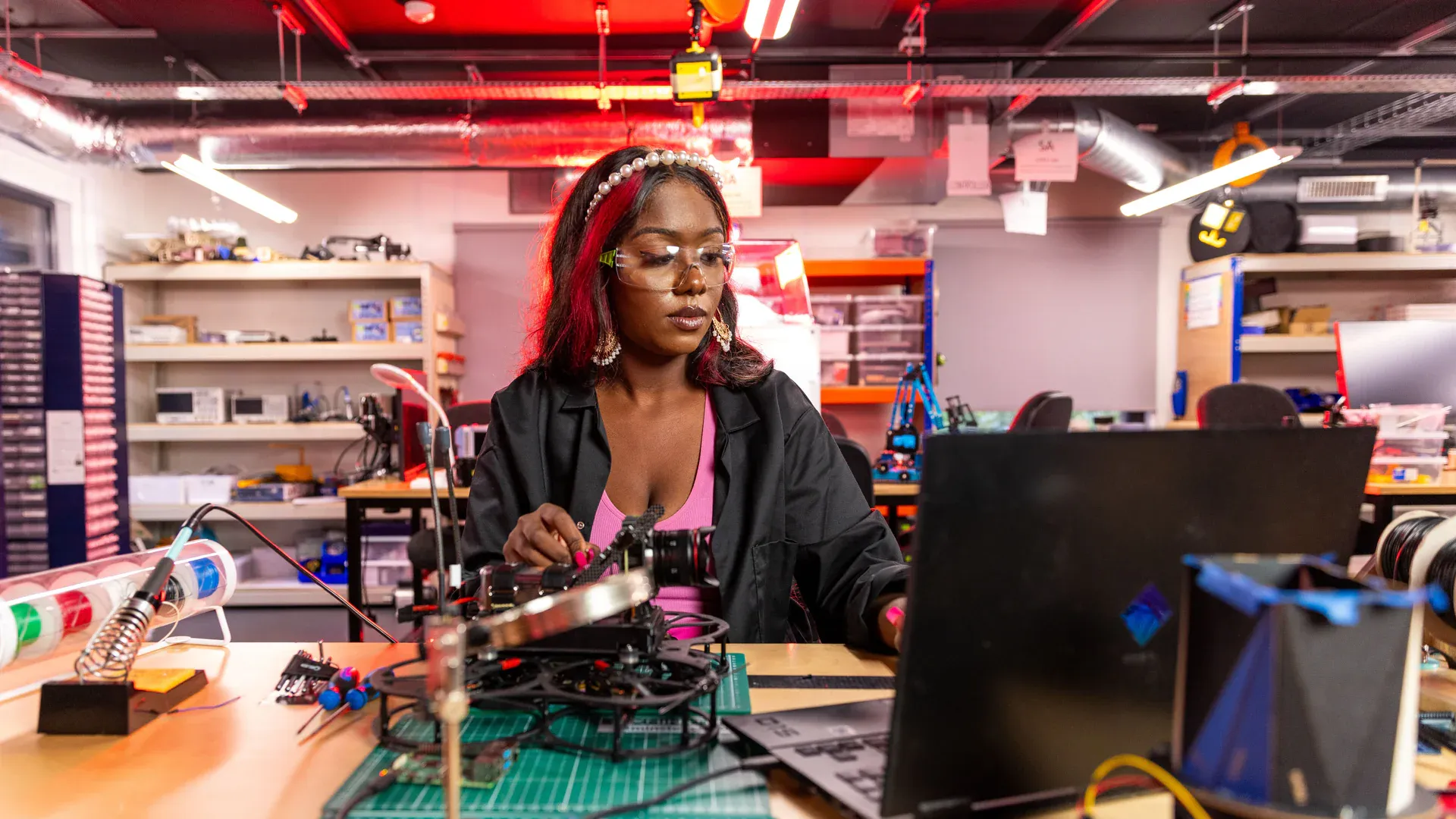 Electronics technician working on a populated circuit board at a repair bench