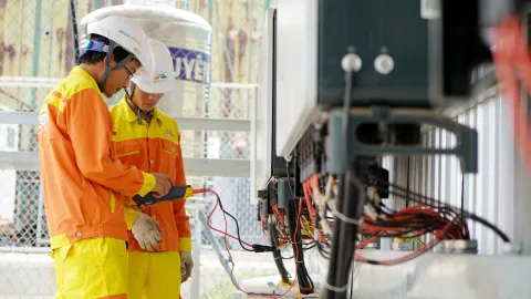 Electrical technicians working around high-power industrial equipment