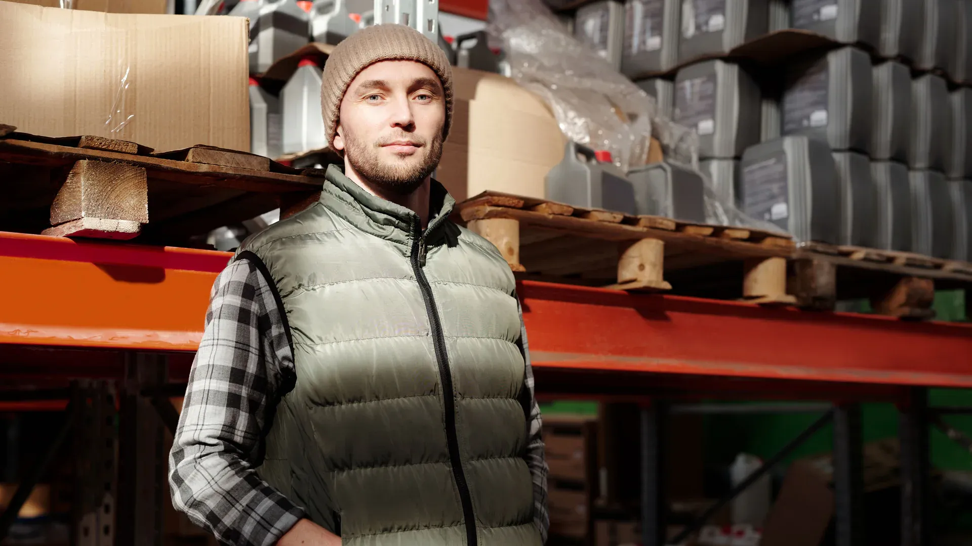 Warehouse specialist standing beside organized inventory shelves