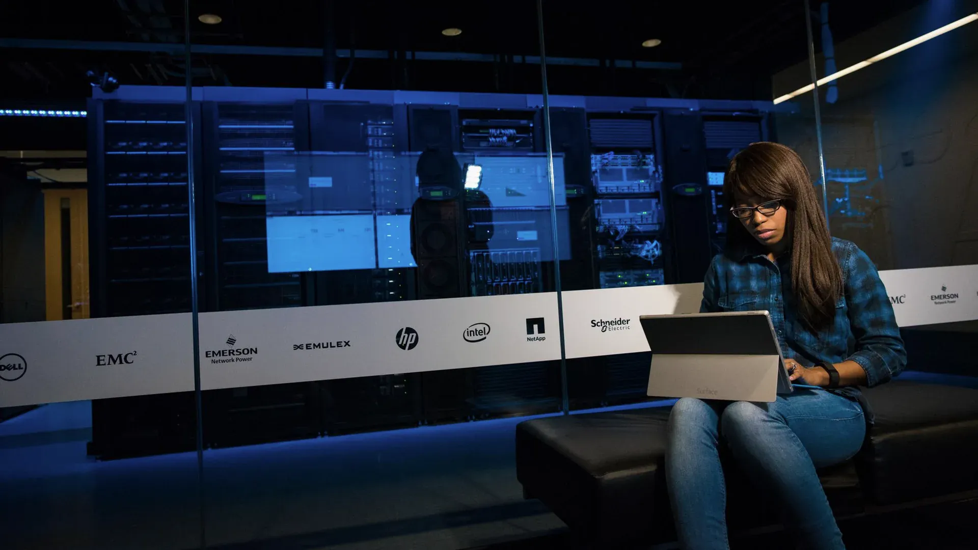 Specialist working on a laptop in a server room while preparing cybersecurity evidence
