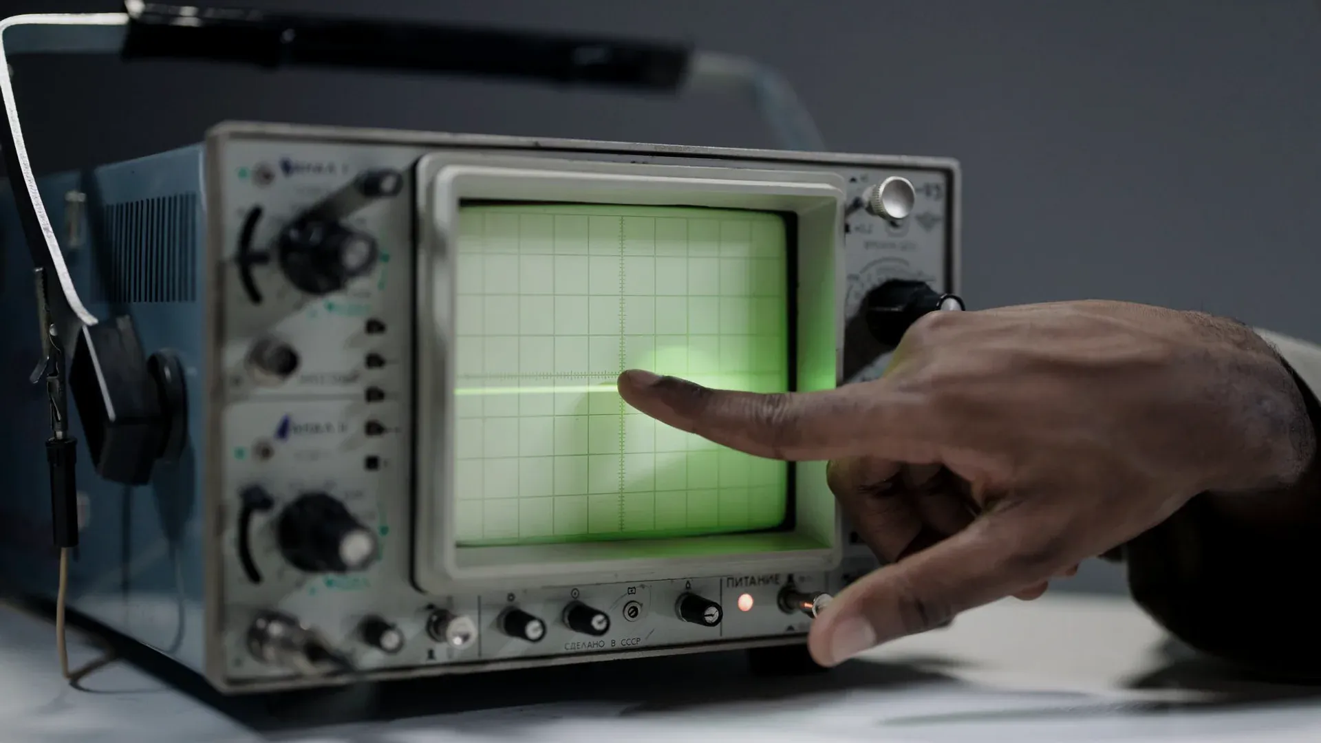 Engineer checking timing signals on an oscilloscope in an electronics laboratory