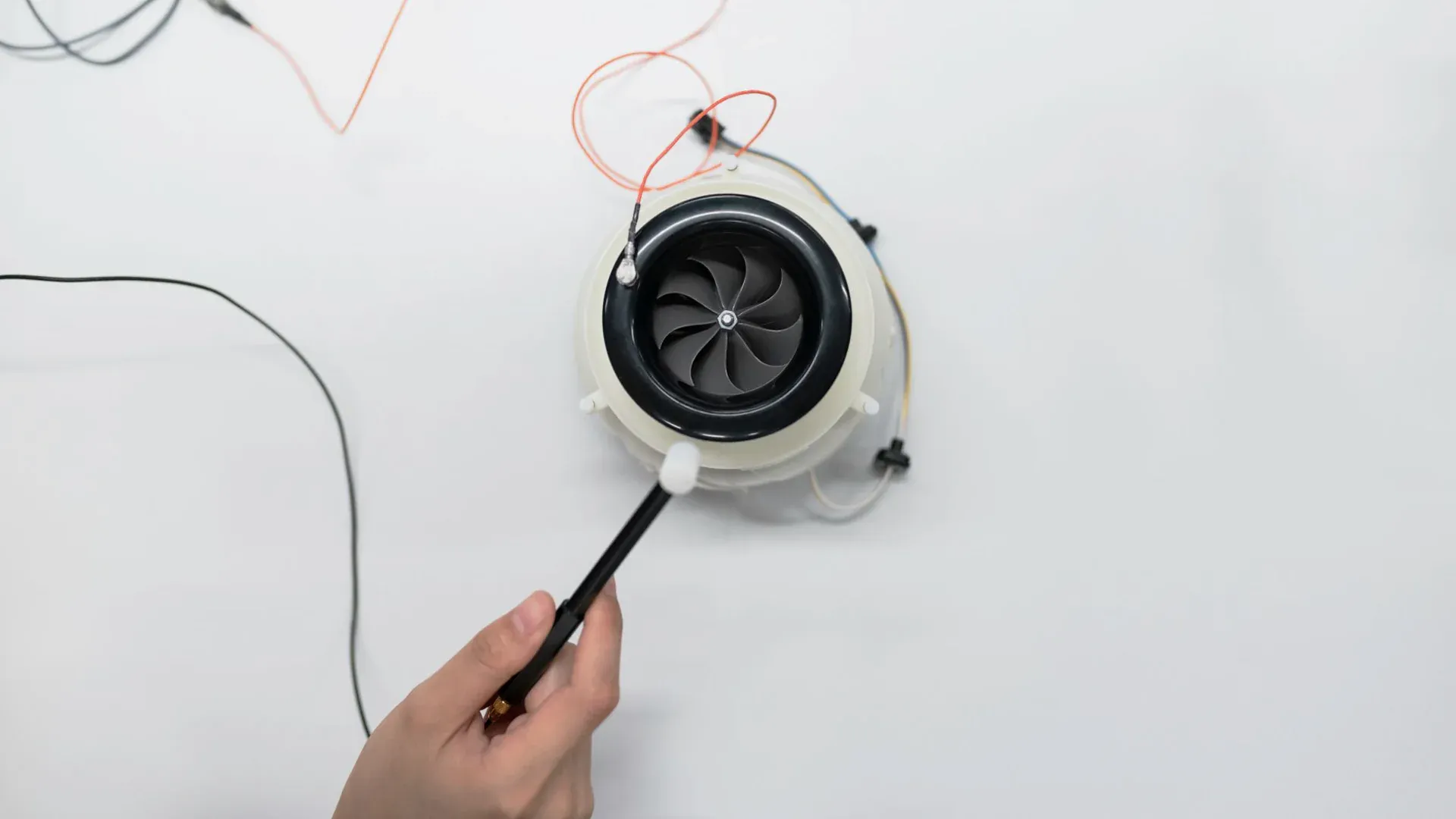Small electric fan under bench inspection representing current sensing in a motor load