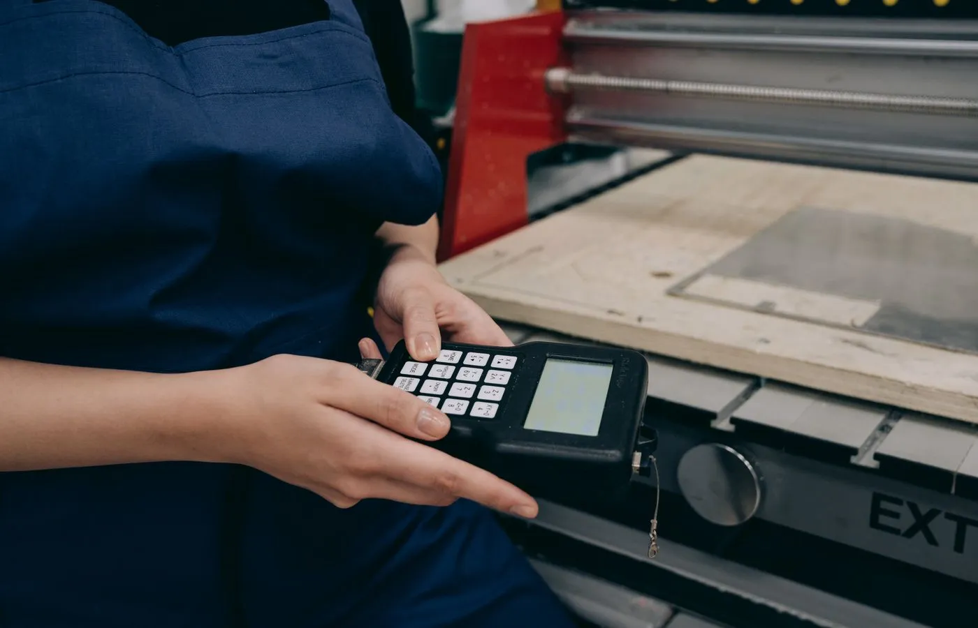 Technician using a handheld industrial machine controller