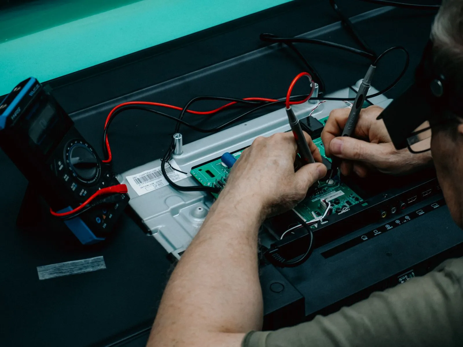 Technician measuring a populated circuit board with electrical probes